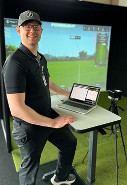 Dr. Watson standing in front of a golf simulator